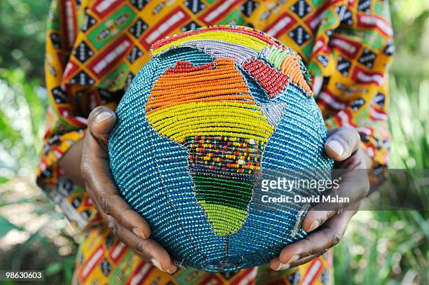 woman holding a beaded globe with africa showing - horn of africa stockfoto's en -beelden