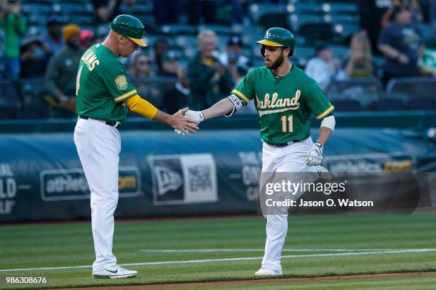 Dustin Fowler of the Oakland Athletics is congratulated by third base coach Matt Williams after hitting a home run against the Kansas City Royals...