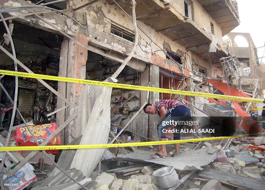 An Iraqi youth clears the rubble outside