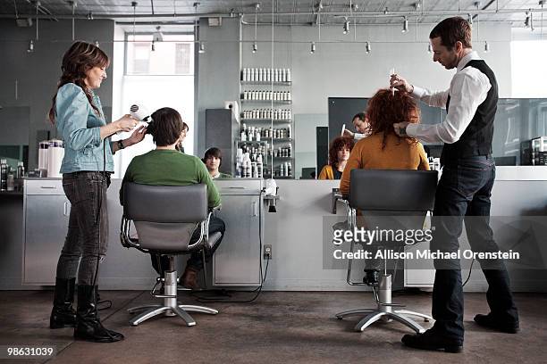 clients getting haircuts in salon - coiffeur photos et images de collection