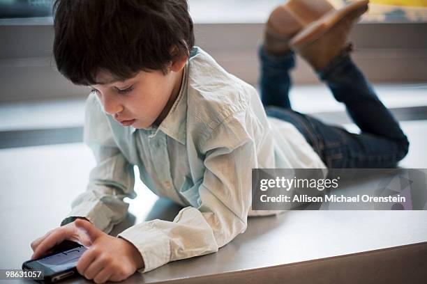 young boy on smart phone playing game - michael virtue stock pictures, royalty-free photos & images