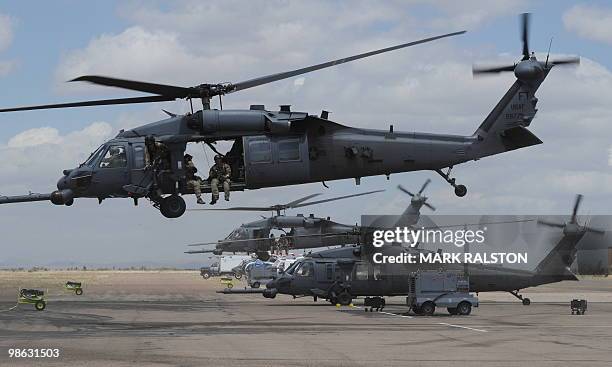 Troops onboard Air Force HH-60 Pave Hawk helicopter leave to conduct a rescue operation during Exercise Angel Thunder, near the town of Bisbee in...