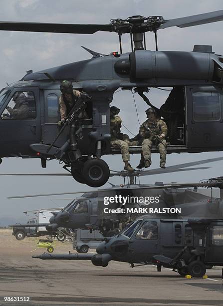 Troops onboard Air Force HH-60 Pave Hawk helicopters leave to conduct a rescue operation during Exercise Angel Thunder, near the town of Bisbee in...