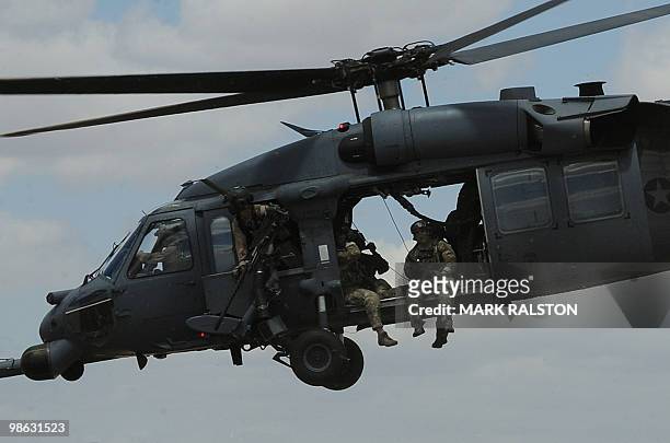 Troops onboard an Air Force HH-60 Pave Hawk helicopter leave to conduct a rescue operation during Exercise Angel Thunder, near the town of Bisbee in...