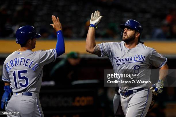 Mike Moustakas of the Kansas City Royals is congratulated by Whit Merrifield after hitting a home run against the Oakland Athletics during the eighth...