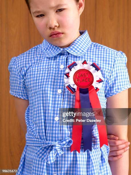 school girl in last place rosette - winners & losers stock-fotos und bilder