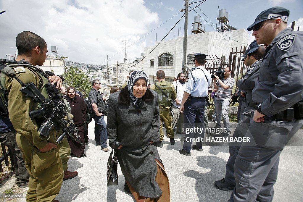 A Palestinian woman walks past Israeli f