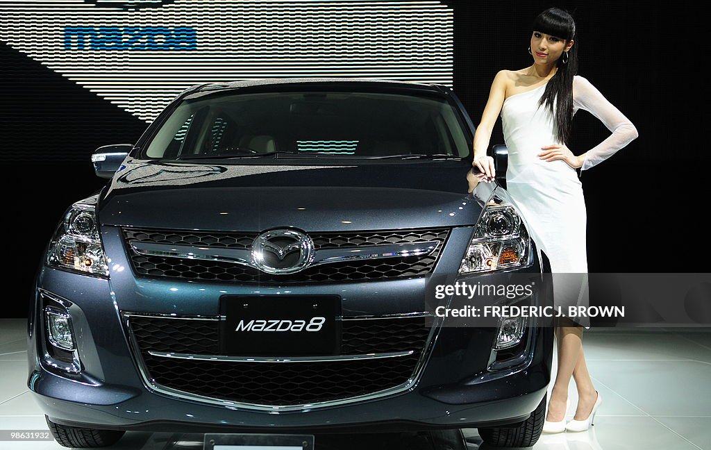 A model poses beside a Mazda 8 during a