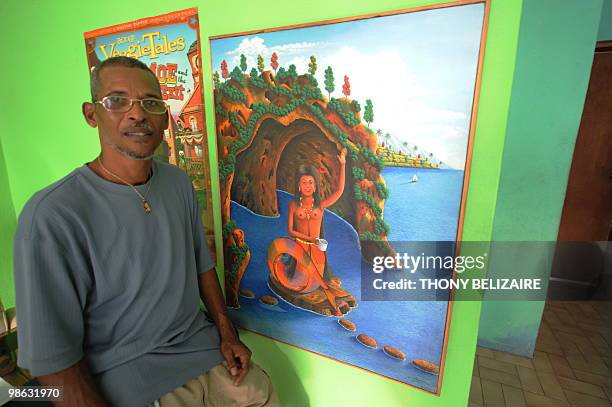 Haitian artist Raymond Bauduy stands next to one of his paintings on April 23, 2010 in Peguy-ville a suburb of Port au Prince. Unlike some of Haiti's...