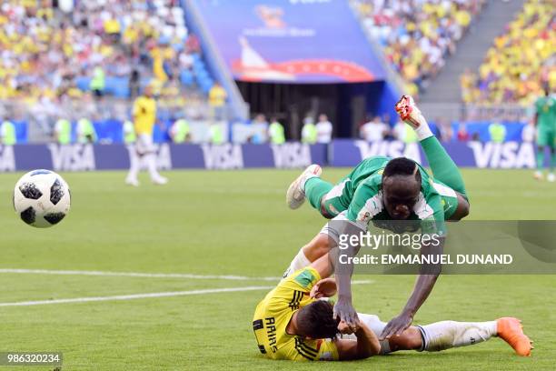 Senegal's forward Sadio Mane falls over Colombia's defender Santiago Arias during the Russia 2018 World Cup Group H football match between Senegal...