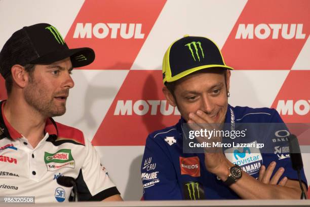 Valentino Rossi of Italy and Movistar Yamaha MotoGP speaks with Cal Crutchlow of Great Britain and LCR Honda during the press conference during the...