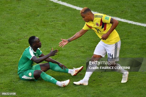 Colombia's forward Luis Muriel helps Senegal's forward Sadio Mane to stand up during the Russia 2018 World Cup Group H football match between Senegal...