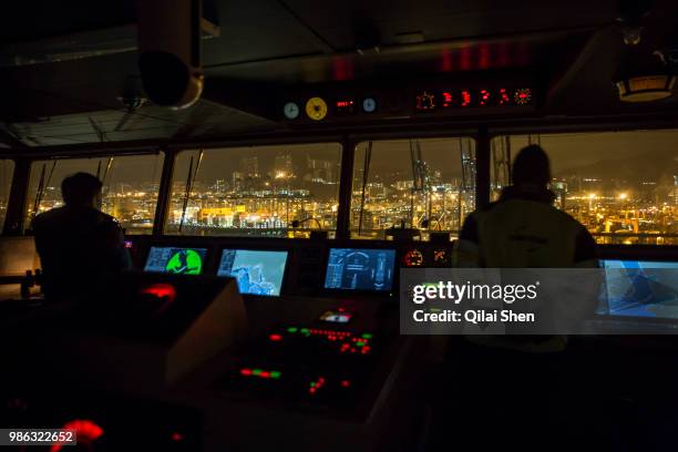 Crew members operate on the bridge of CMA CGM SA's Benjamin Franklin container ship as it enters Hong Kong Harbour in Hongkong, China, on Tuesday,...