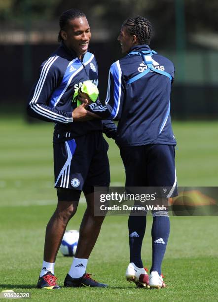 Didier Drogba and Patrick Van Aanholt of Chelsea share a joke during a training session at the Cobham Training Ground on April 23, 2010 in Cobham,...