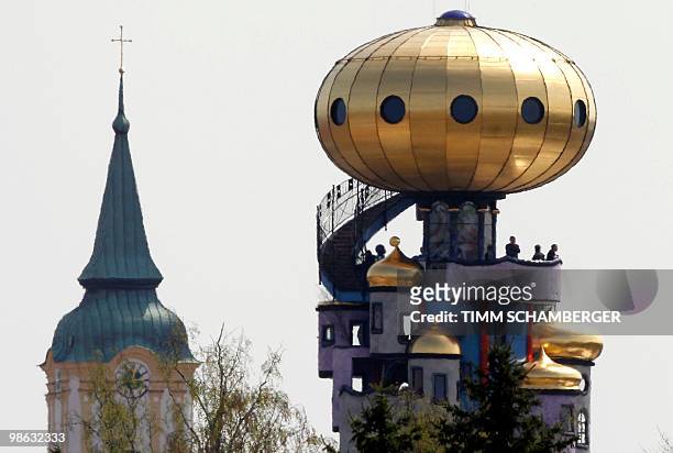 The Hundertwasser Tower, built by Austrian architect Friedensreich Hundertwasser is pictured next to a church tower in Abensberg, southern Germany on...