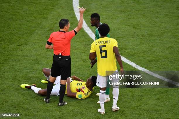 Serbian referee Milorad Mazic gives a yellow card to Senegal's forward Mbaye Niang next to Colombia's defender Yerry Mina reacting on the football...