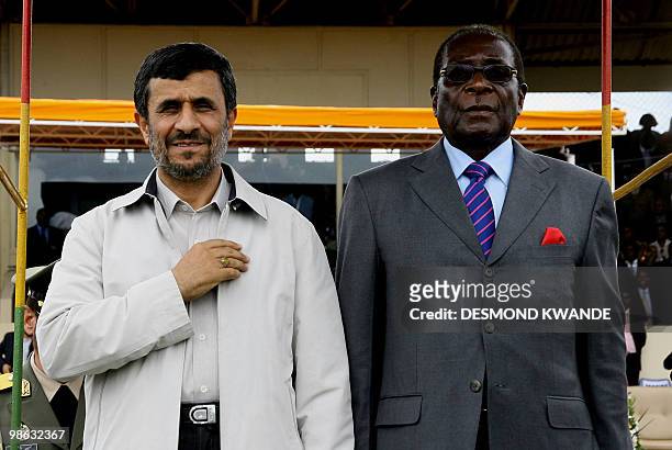 Zimbabwe's President Robert Mugabe stands with Iranian President Mahmoud Ahmadinejad at a parade during the official opening of a trade fair on April...