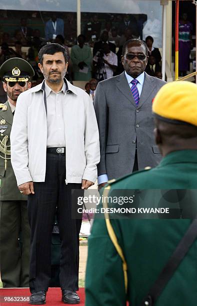 Zimbabwean President Robert Mugabe and Iranian President Mahmoud Ahmadinejad stand at a parade during the official opening of the international trade...