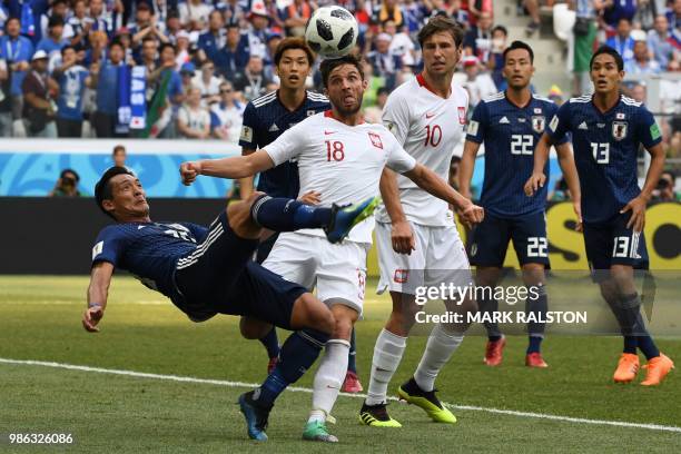 Japan's defender Tomoaki Makino makes a bycicle kick past Poland's defender Bartosz Bereszynski and Poland's midfielder Grzegorz Krychowiak during...