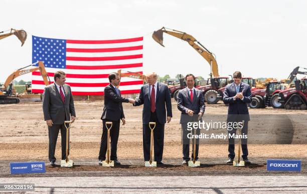 President Donald Trump shakes hanks with Wisconsin Gov. Scott Walker at the groundbreaking of the Foxconn Technology Group computer screen plant on...