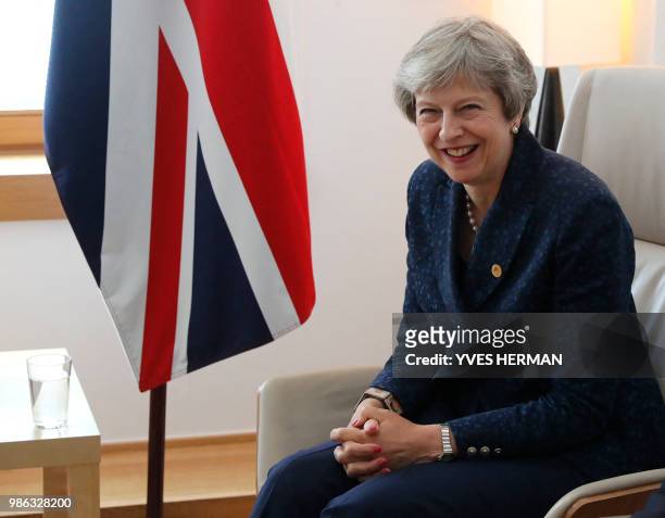 British Prime Minister Theresa May laughs during a bilateral meeting with Irish Prime minister during an European Union leaders' summit focused on...