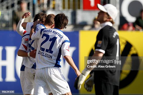 Kai Buelow of Rostock celebrates his team's first goal with team mates as goalkeeper Tobias Sippel of Kaiserslautern reacts during the Second...