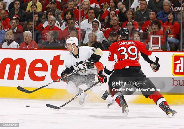 Tyler Kennedy of the Pittsburgh Penguins plays the puck as Matt Carkner of the Ottawa Senators defends in Game 4 of the Eastern Conference...