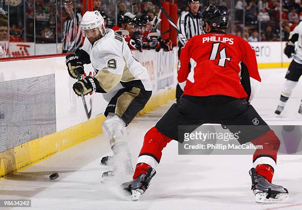 Pascal Dupuis of the Pittsburgh Penguins plays the puck as Chris Phillips of the Ottawa Senators defends in Game 4 of the Eastern Conference...