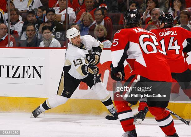Bill Guerin of the Pittsburgh Penguins shoots against Chris Campoli and Erik Karlsson of the Ottawa Senators in Game 4 of the Eastern Conference...