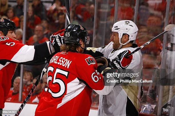 Michael Rupp of the Pittsburgh Penguins gets into a scuffle with Andy Sutton and Erik Karlsson of the Ottawa Senators in Game 4 of the Eastern...