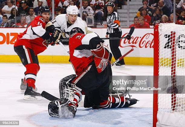 Goaltender Pascal Leclaire of the Ottawa Senators attempts a save as Jordan Staal of the Pittsburgh Penguins gets his stick blade on the puck in mid...