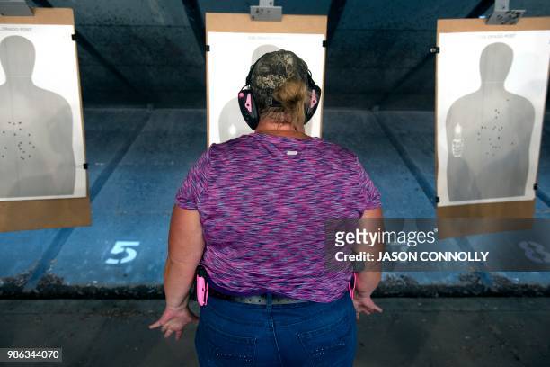 Trainee prepares to fire her gun at a target during a three day firearms training course for school teachers and administrators sponsored by FASTER...