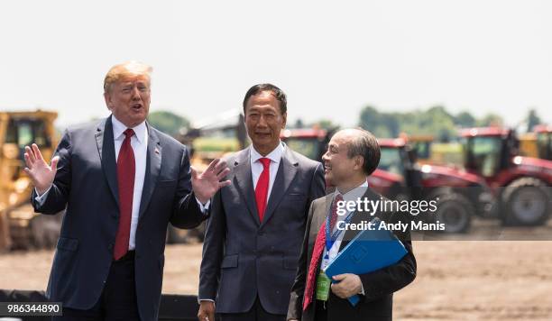 President Donald Trump talks as Foxconn CEO Terry Gou and Masayoshi Son, chairman and CEO of SoftBank Group look on at the groundbreaking for the...