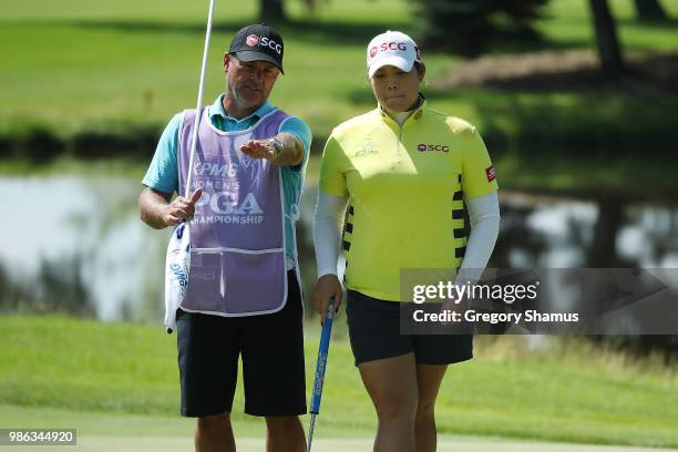 Ariya Jutanugarn of Thailand talks with her caddie on the eighth green during the first round of the 2018 KPMG PGA Championship at Kemper Lakes Golf...