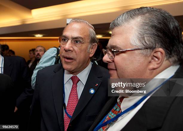 Agustin Carstens, governor of the central bank of Mexico, right, talks to Angel Gurria, secretary-general of the Organization for Economic...