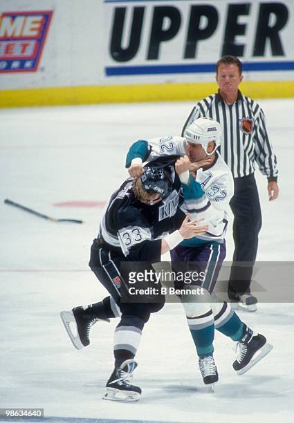 Stu Grimson of the Mighty Ducks of Anaheim fights with Marty McSorley of the Los Angeles Kings during an NHL game circa 1994 at the Pond in Anaheim,...