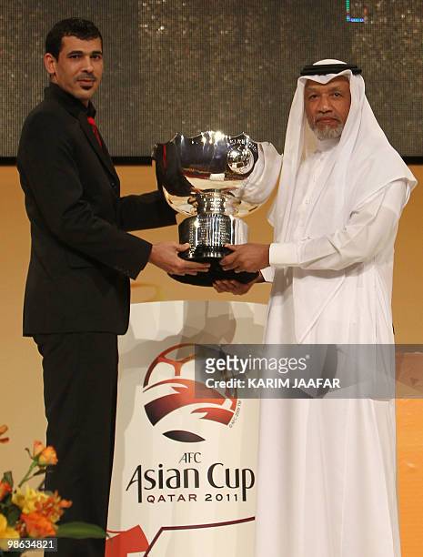 Iraqi national team player Yunes Mahmud hands the cup his football team won at the 2007 AFC Asian Cup to Asian Football Confederation president...