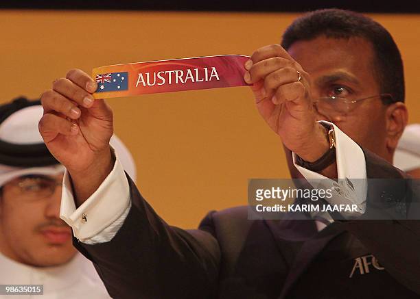 General-Secretary of the Asian Football Confederation Alex Soosay holds up a slip of paper bearing the name Australia during the final draw for the...