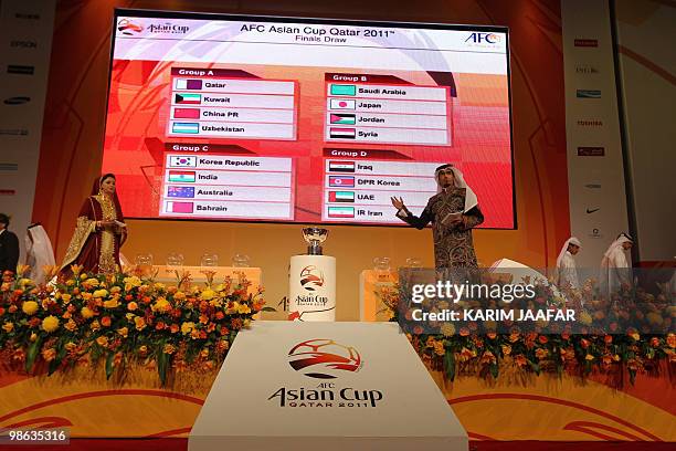 The final draw result of the Asian Football Confederation 2011 Asian Cup soccer tournament is displayed on a screen next to the trophy at the Aspire...