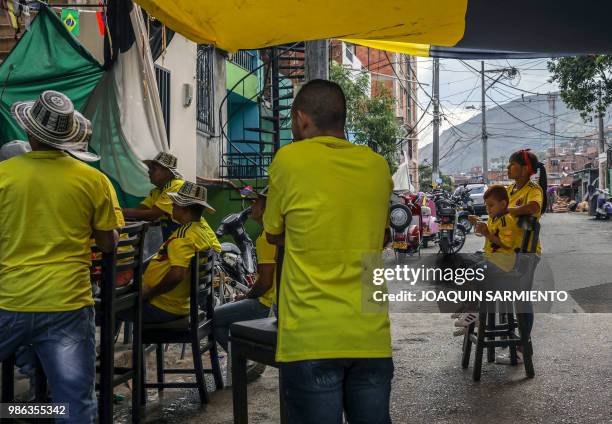 People watch the World Cup match between Colombia and Senegal on TV at the Comuna Popular 1 in Medellin, Colombia, on June 28, 2018. - Colombia beat...