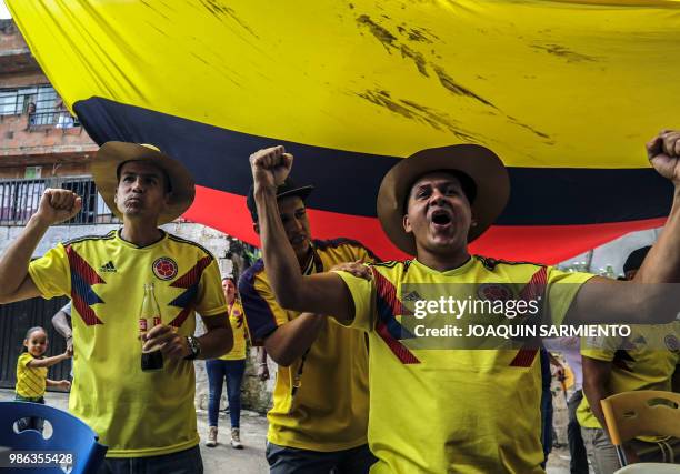 People watch the World Cup match between Colombia and Senegal on TV at the Comuna Popular 1 in Medellin, Colombia, on June 28, 2018. - Colombia beat...