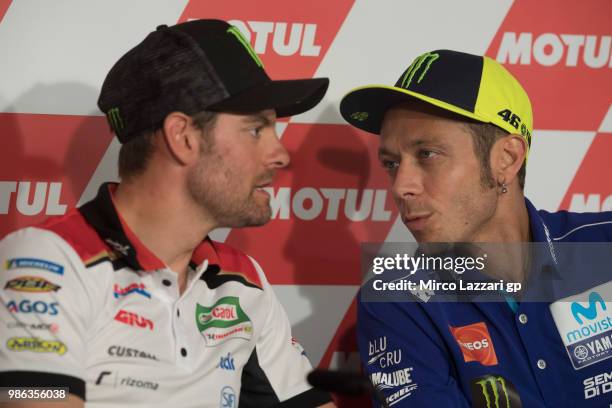 Valentino Rossi of Italy and Movistar Yamaha MotoGP speaks with Cal Crutchlow of Great Britain and LCR Honda during the press conference during the...