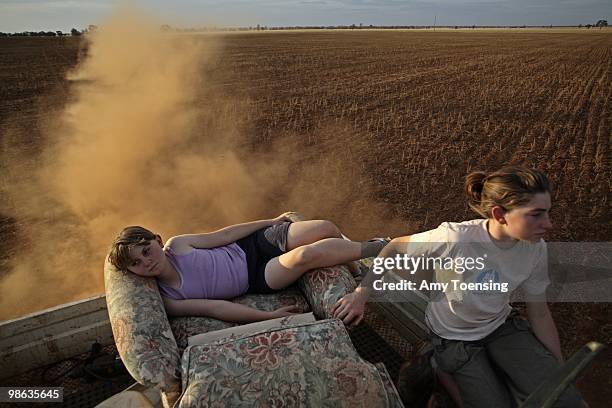 Hannah and Alice Kenny ride in the back of their father's pick-up truck through one of the failed wheat crops on their farm October 22, 2008 in...