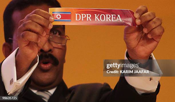 General-Secretary of the Asian Football Confederation Alex Soosay holds up a slip of paper carrying the name North Korea during the final draw for...