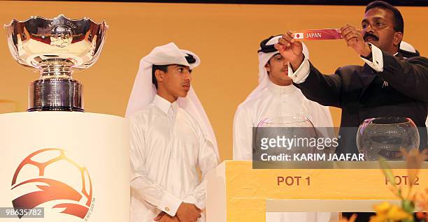 General-Secretary of the Asian Football Confederation Alex Soosay holds up a slip of paper bearing the name Japan during the final draw for the 2011...