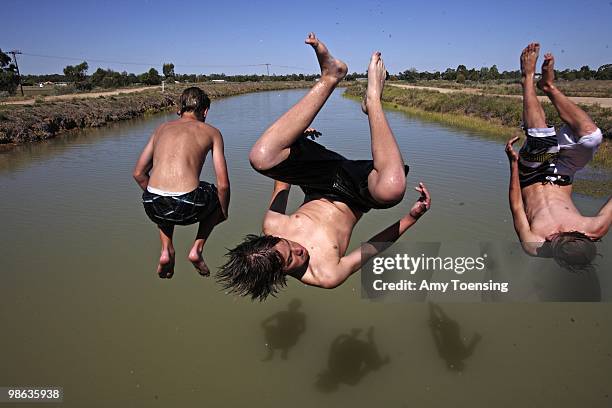 Hayden Cuppens, middle, Brayden Mackey, left and Jaydyn Lehmann jump off a bridge into the Mulwala Canal February 16, 2008 in Deniliquin, New South...