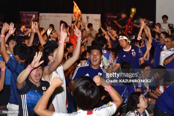 Supporters celebrate Japan's qualifying while watching Japan's third World Cup football match in Group H against Poland at a public viewing in Tokyo...