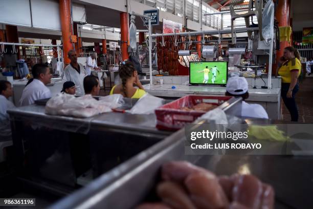 People watch the World Cup match between Colombia and Senegal on TV at a popular market in Cali, Colombia, on June 28, 2018. - Colombia beat Senegal...