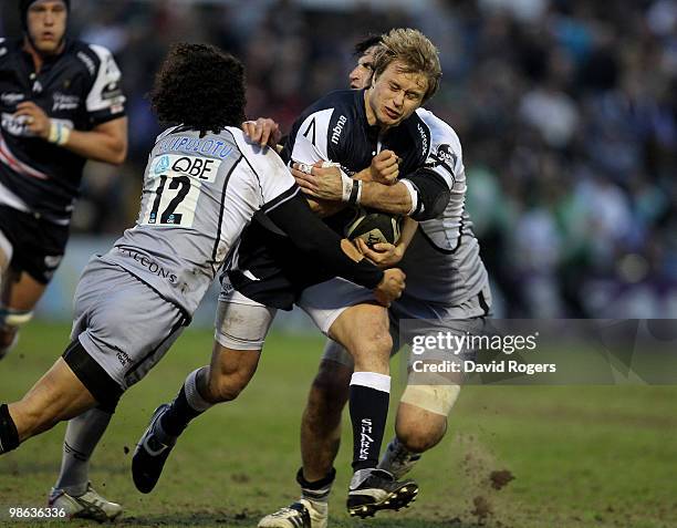 Mathew Tait of Sale is tackled by Tane Tu'ipuotu and Brent Wilson during the Guinness Premiership match between Sale Sharks and Newcastle Falcons at...