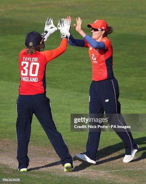 England's Natalie Sciver celebrates with England wicketkeeper Sarah Taylor after taking the catch of New Zealand's Sophie Devine during the T20 Tri...